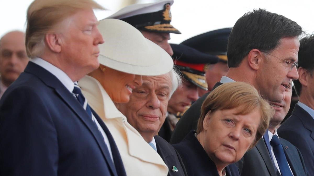 La cancillera alemana, Angela Merkel, mira al presidente de EEUU, Donald Trump, durante los actos de conmemoración del desembarco de Normandía.