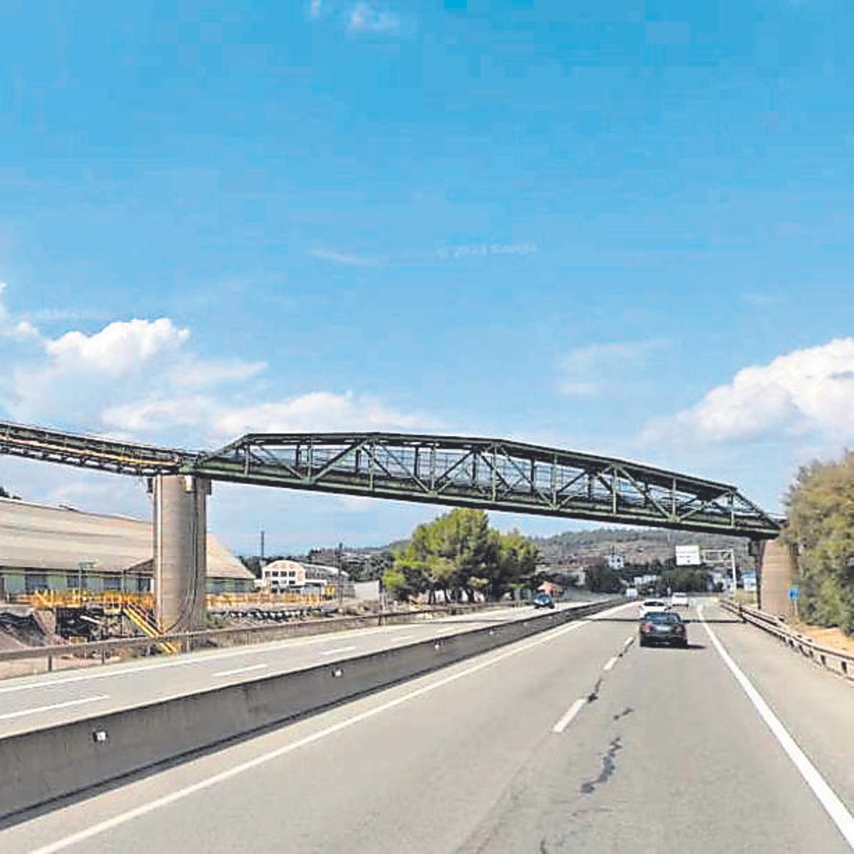 La passarel·la transportadora de la fàbrica, actualment en desús, travessa la carretera C-16