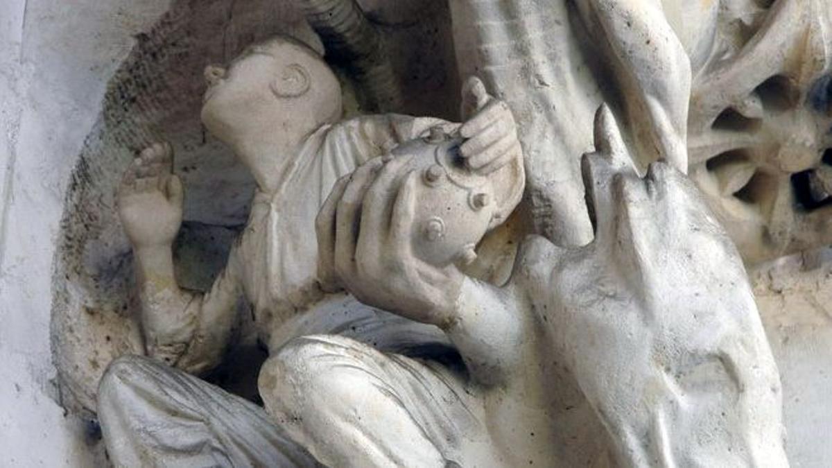 Una anarquista recibe una bomba Orsini de manos de un serpenteante demonio, en la fachada principal de la Sagrada Família.