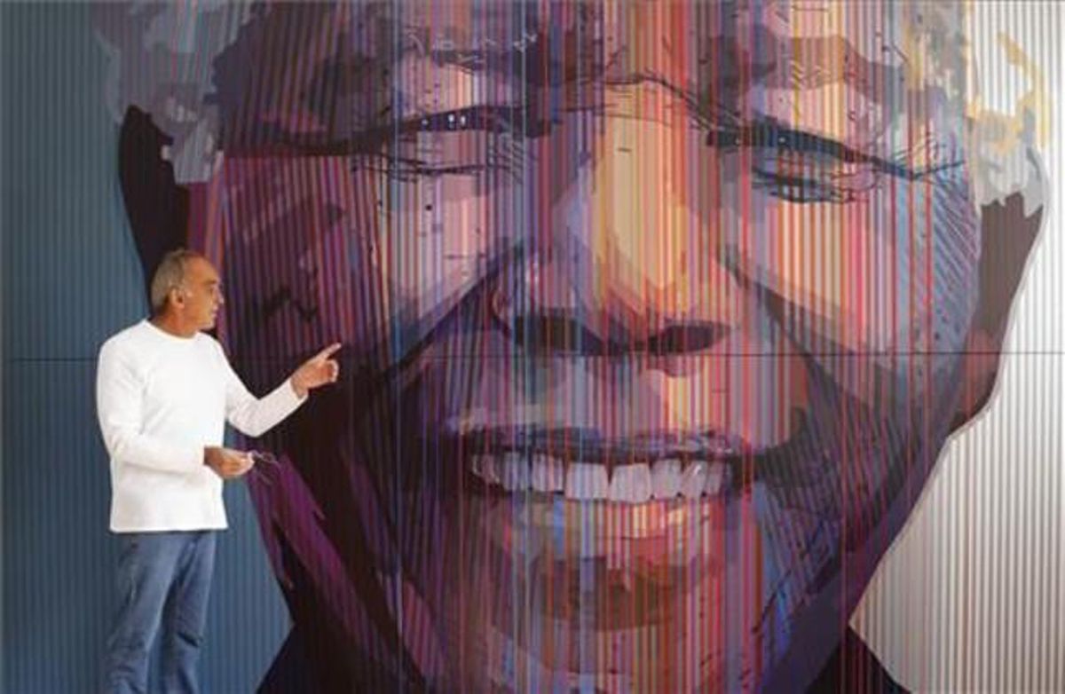 L’artista sud-africà Paul Blomkamp, davant d’un retrat gegant de Mandela al seu estudi de Johannesburg, el 23 de maig del 2013, per preparar el 95è aniversari de l’expresident sud-africà.
