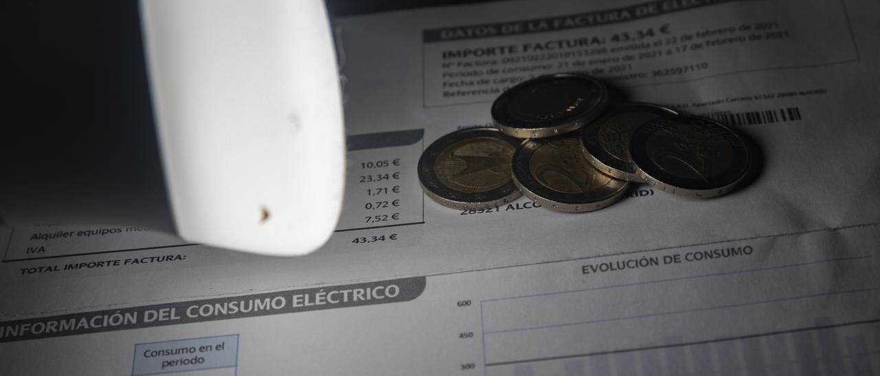 Una lámpara refleja el importe de una factura el día en que el precio de la luz ha marcado un mínimo por primera vez en dos meses, a 27 de diciembre de 2021, en Madrid, (España). El precio medio de la electricidad en el mercado mayorista registr