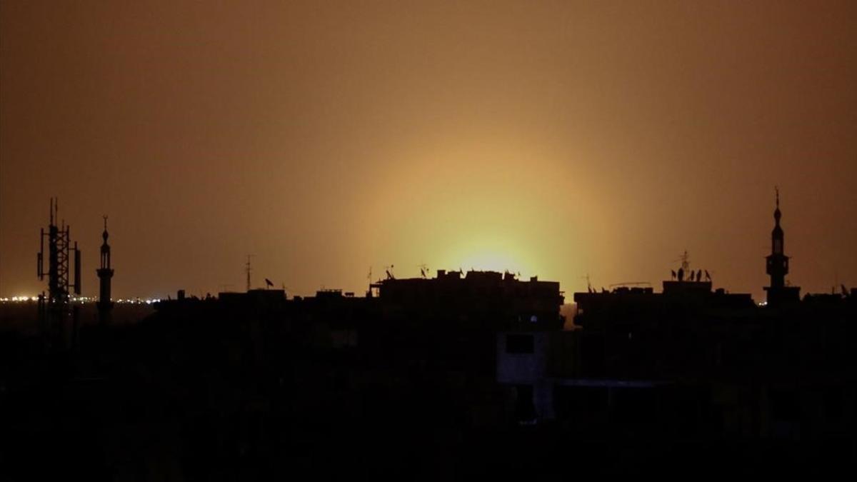 Foto tomada desde la ciudad de Duma, en la que se observan las llamas a distancia provocadas por la fuerte explosión en el aeropuerto internacional de Damasco, el 27 de abril.