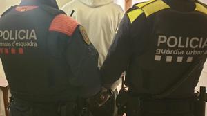 Un agente de Mossos y otro de la Guardia Urbana portando a un detenido en Barcelona.