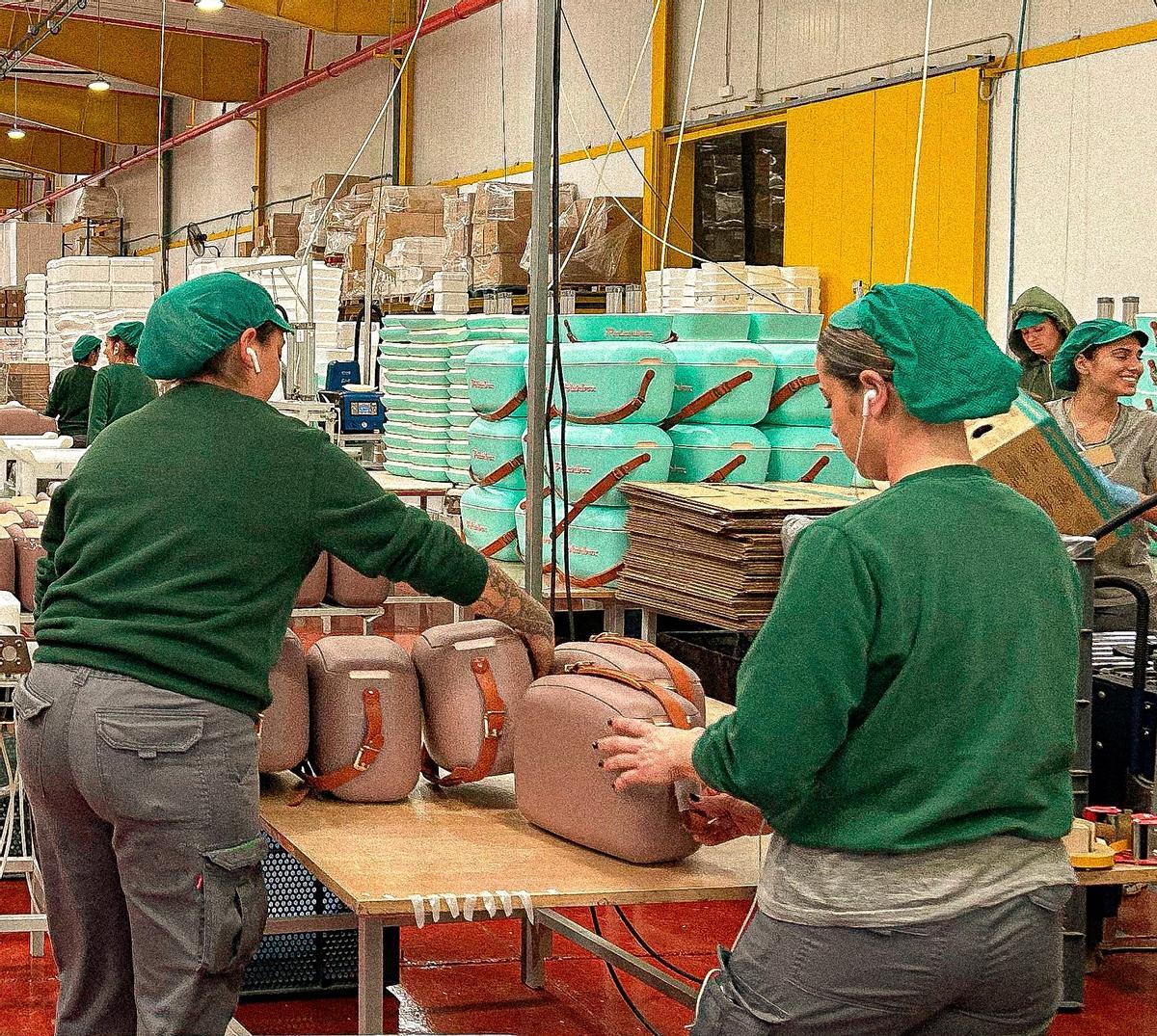 Trabajadoras de la empresa Polisur en la cadena de producción de la gama más elegante de las neveras Polarbox, con una correa de piel para llevarla al hombro como si fuera un bolso.