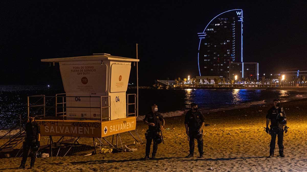 Agentes garantizan el cumplimiento del toque de queda en la playa de la Barceloneta