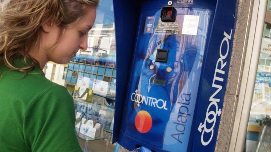Una joven compra condones en una máquina expendedora. |  // DIANA DÍAZ