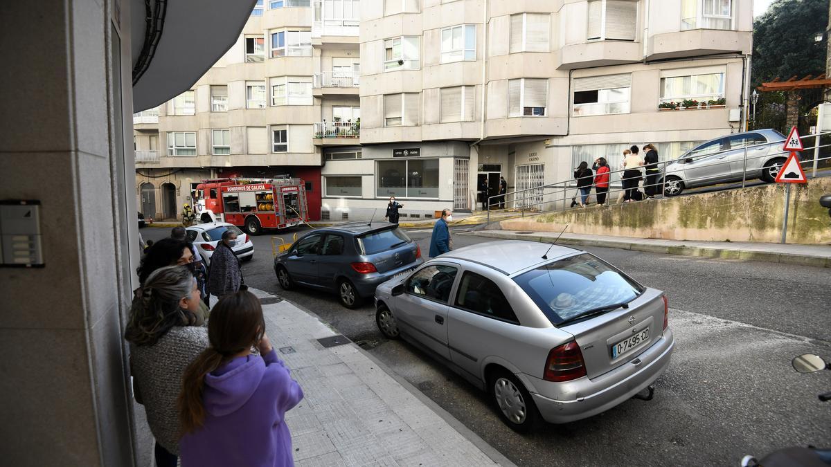 Bomberos apagando el fuego ante la expectación de los vecinos desalojados del inmueble