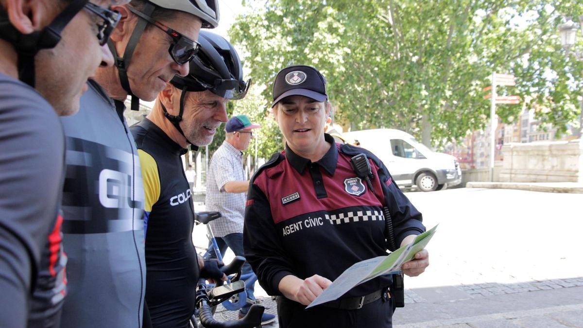 Imatge d'arxiu d'una agent cívic de Girona informant a un grup de ciclistes