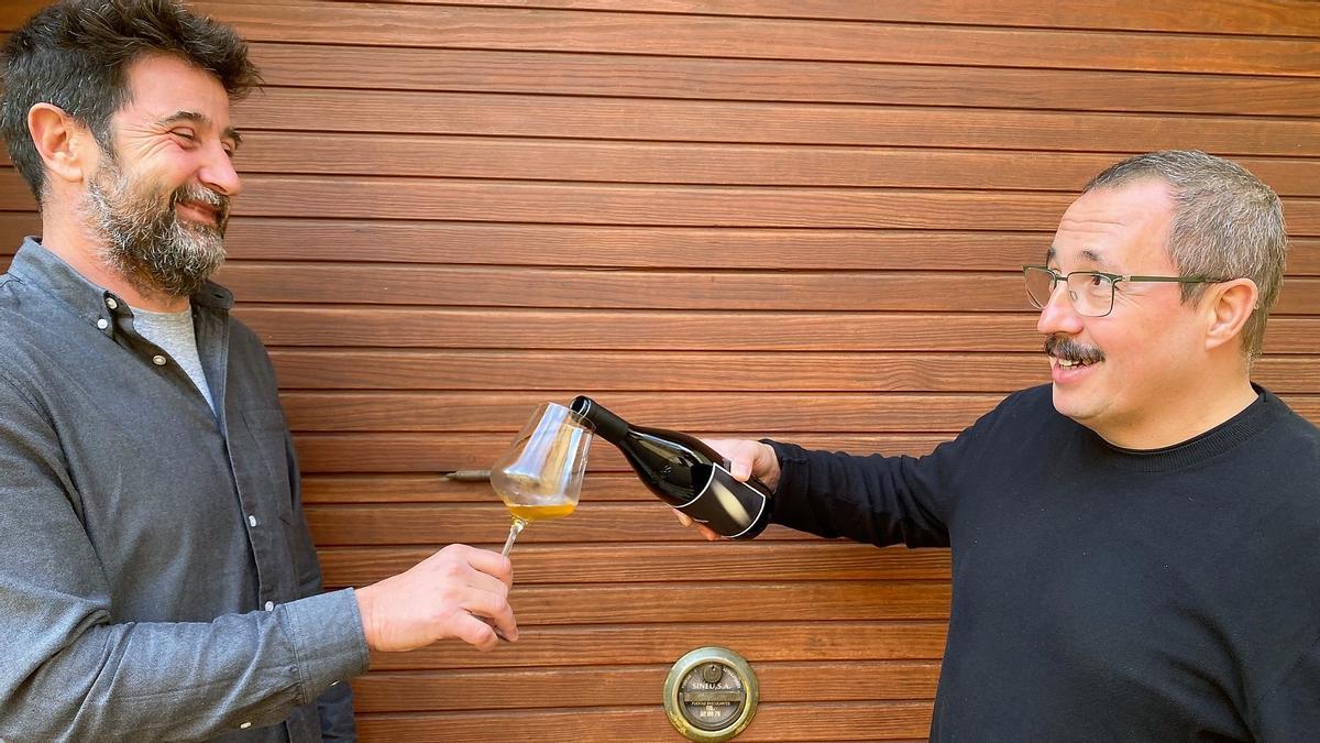 El enólogo Francesc Grimalt y Sergio Caballero, músico cofundador del festival Sónar, con uno de los vinos de su bodega, 4Kilos Vinícola (Felanitx).