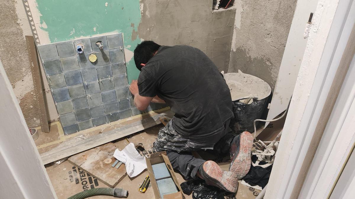 Un albañil realiza trabajos en el lavabo de una vivienda. / Archivo