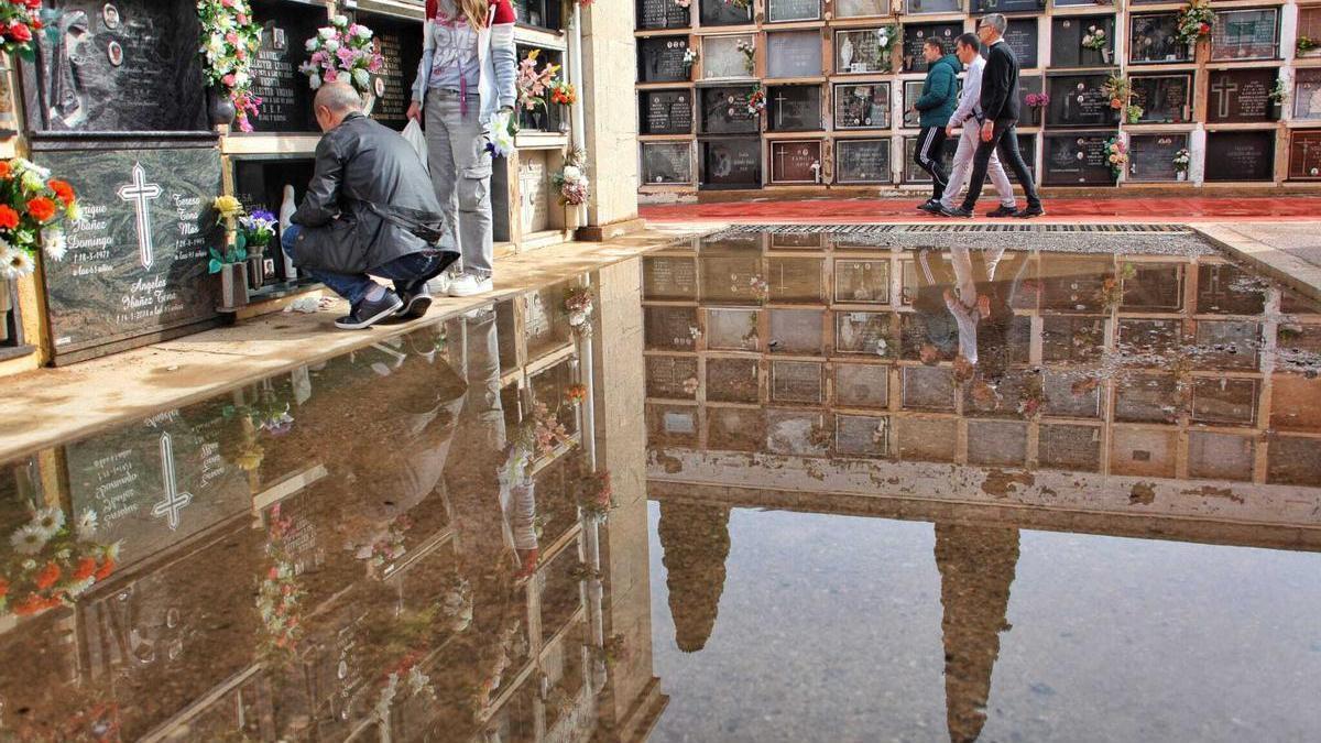 Varias personas evitan ayer el agua en una de las zonas del cementerio de San José, en Castelló.