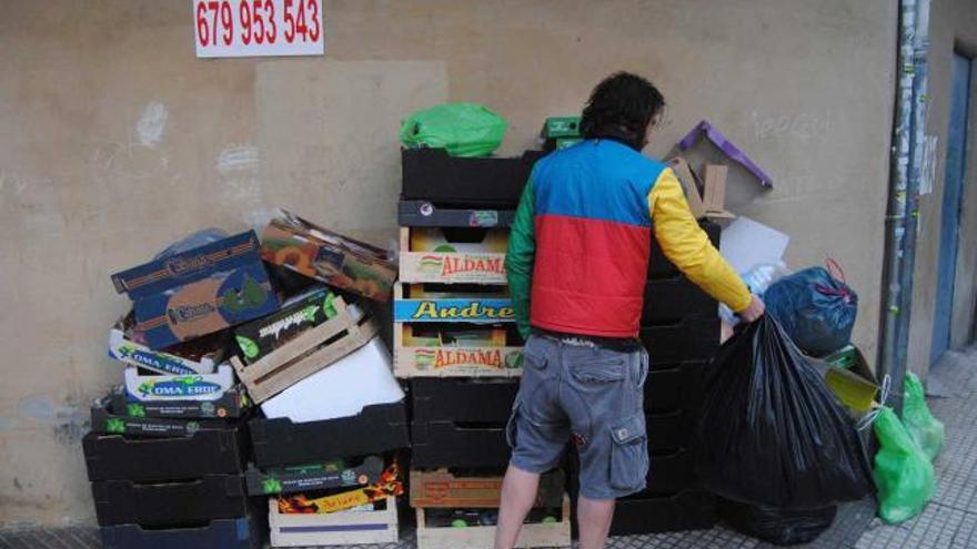 Un hombre, ayer, tirando las bolsas de basura en la Pola.