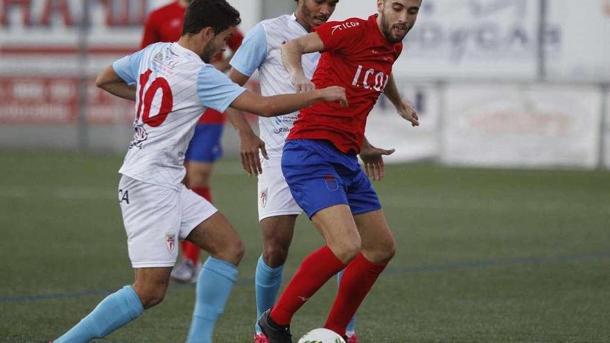 Dos jugadores del Compostela presionan a uno del Choco durante el partido de ayer. // Ricardo Grobas