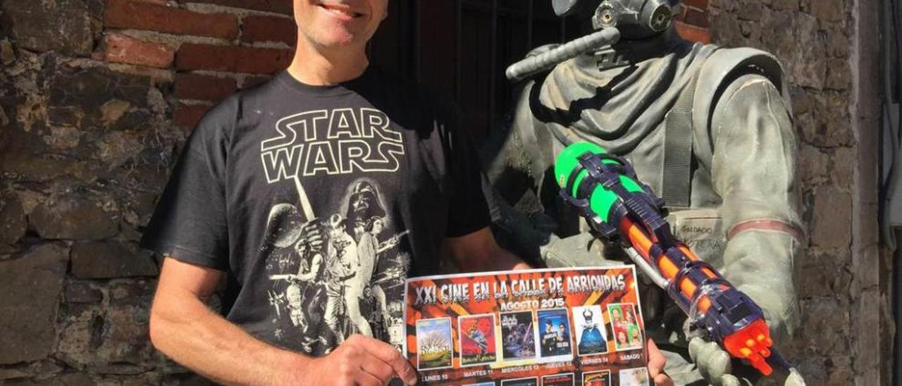 Miguel Ángel Aramburu, con el cartel de la XXI Edición de Cine en la calle de Arriondas, junto a un muñeco.