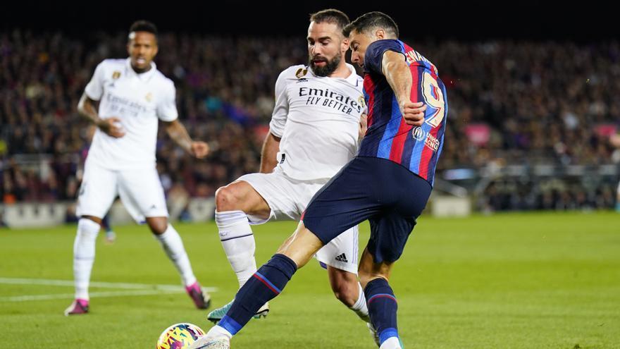 El delantero del FC Barcelona Robert Lewandowski (d) lucha con Dani Carvajal, del Real Madrid, durante el encuentro correspondiente a la jornada 26 de Liga en Primera División que FC Barcelona y Real Madrid disputan hoy domingo en el Camp Nou, en Barcelona.