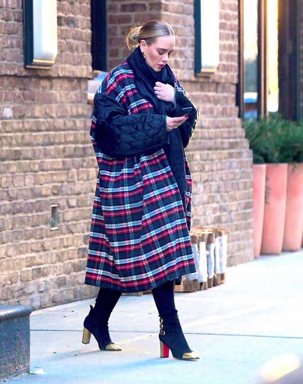 Adele con un abrigo caminando por la calle