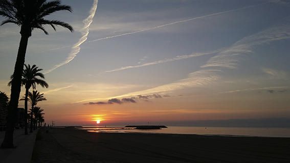 Sol naixent. De bon matí i des de la platja de Cunit es veia sortir un sol rogenc; cel clar solcat per rastres d’avions i la mar ben plana.