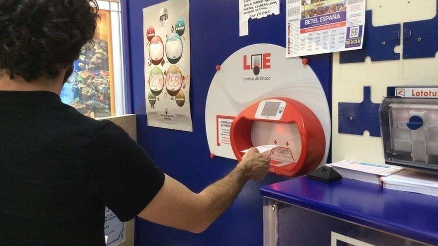 Un hombre comprueba un boleto de Loterías en una administración cordobesa.