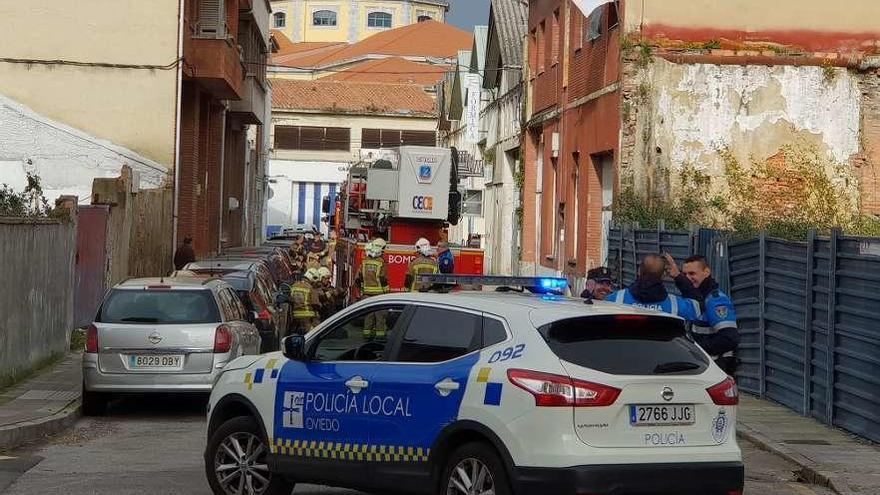 Agentes de la Policía Local y bomberos, ayer, junto a la nave donde se produjo el fuego, a la derecha.