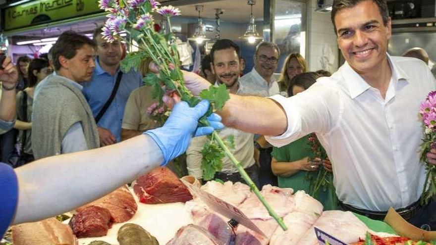 Sánchez, ayer, entregando flores en un mercado de Ibiza. // Efe