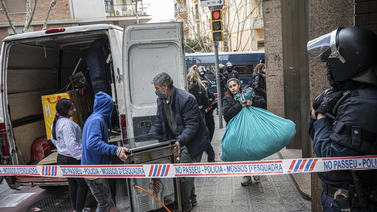 Una familia carga sus pertenencias en una furgoneta tras ser desahuciada en Barcelona.