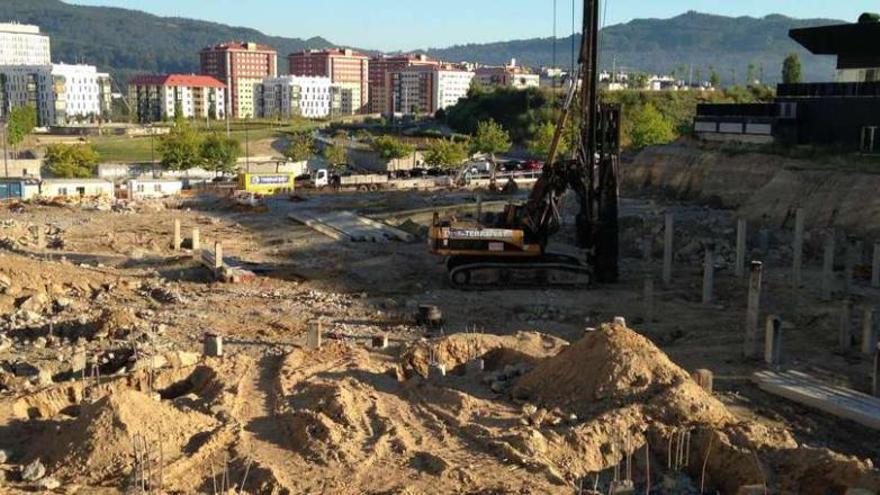 Vista de las obras del futuro complejo del barrio de Navia, con los edificios de la calle Teixugueiras al fondo