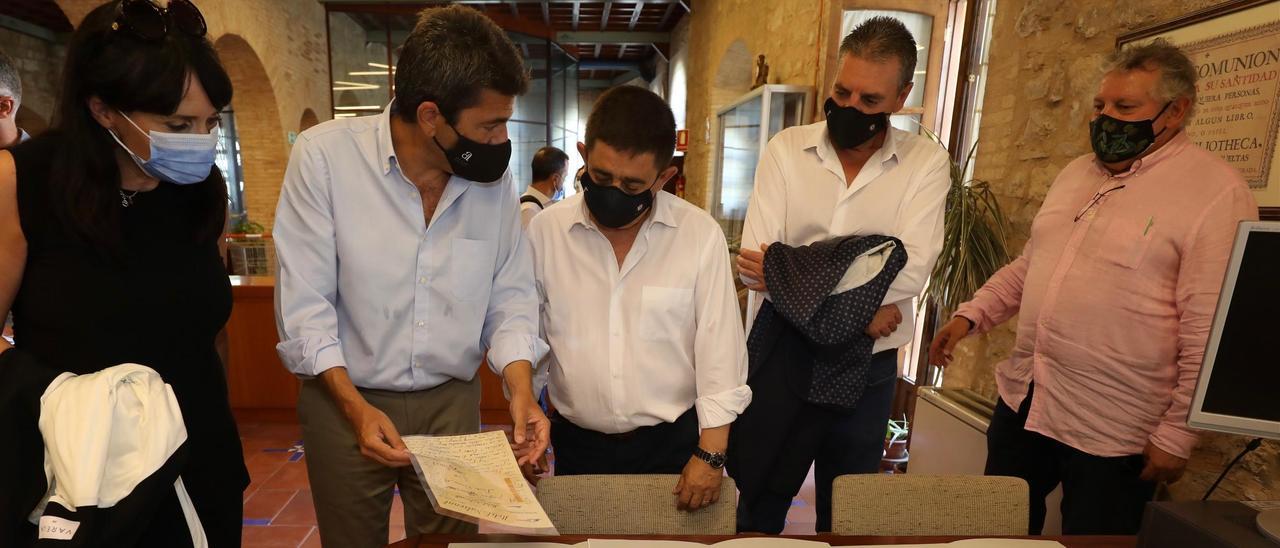 Julia Parra, a la izquierda, junto a Carlos Mazón y el resto de autoridades observando documentos del poeta tras la firma del acuerdo.