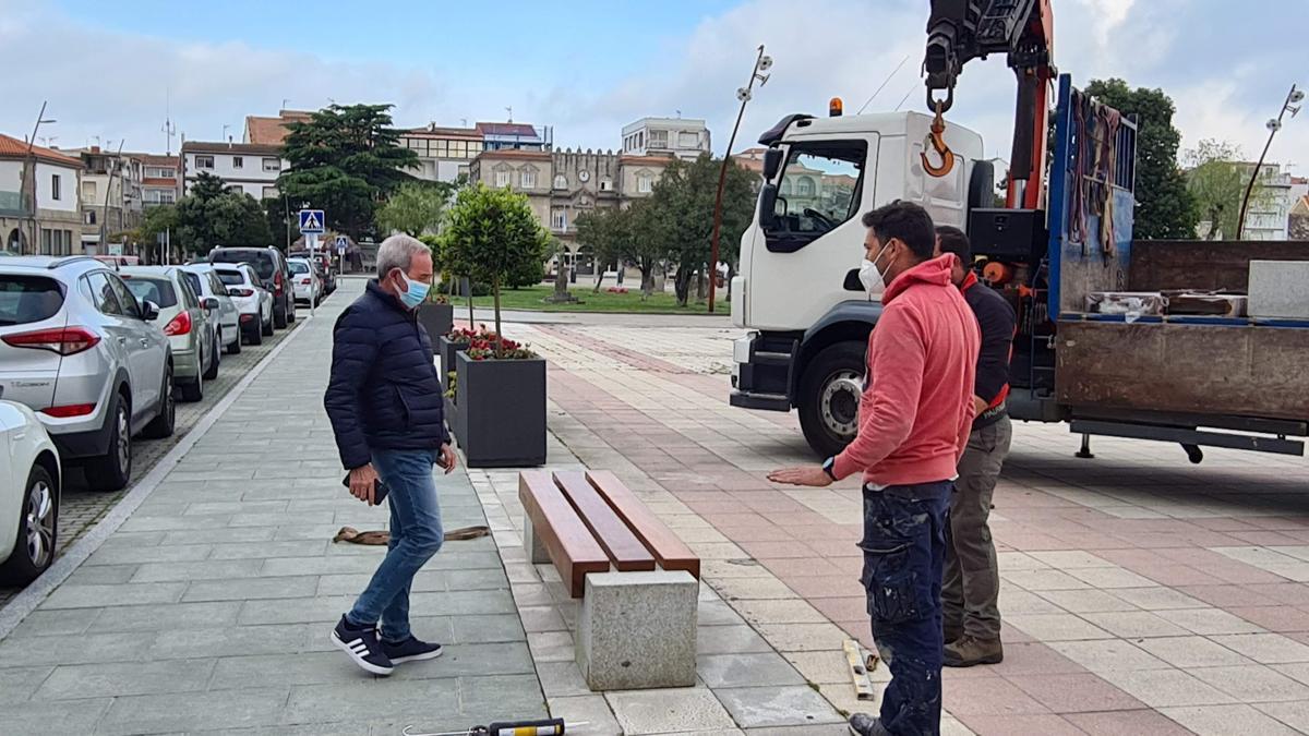 El edil Juan Ramón Outeda supervisa la instalación de un banco, en O Corgo.