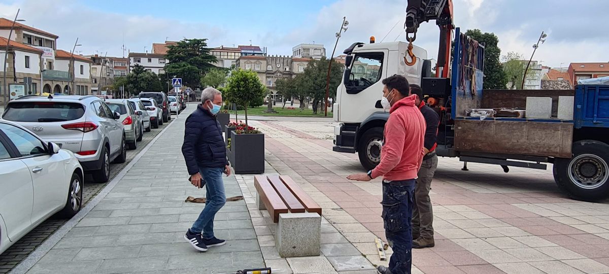 El edil Juan Ramón Outeda supervisa la instalación de un banco, en O Corgo.