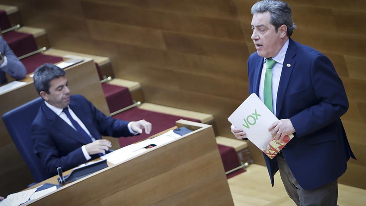 El portavoz de Vox, José María Llanos, pasa por delante de Mazón.