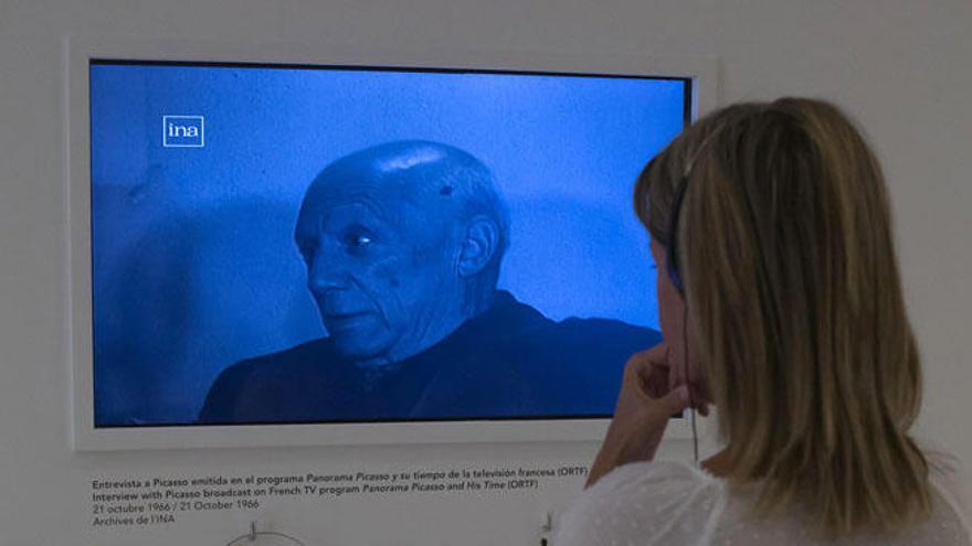 Una mujer escucha una entrevista del artista malagueño emitida en el programa Panorama Picasso y su tiempo de la televisión francesa (ORTF), que se puede ver en la exposición inaugurada hoy en el Museo Picasso Málaga, &quot;Picasso TV&quot;.