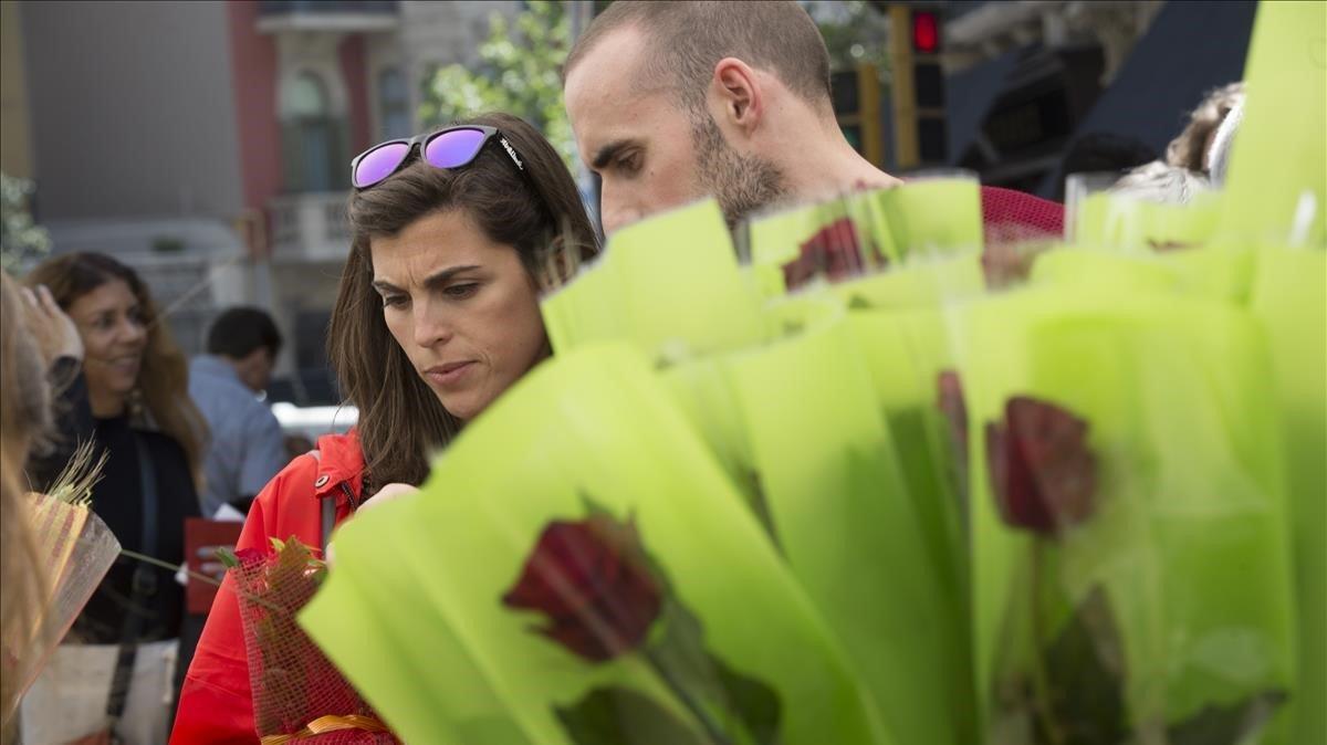 Una pareja junto a una parada de flores.