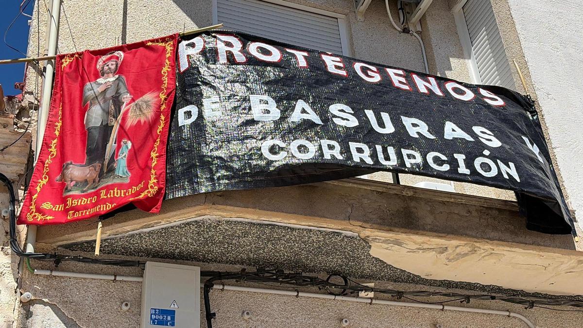 Pancarta que pide la protección de San Isidro Labrador en un balcón de Torremendo