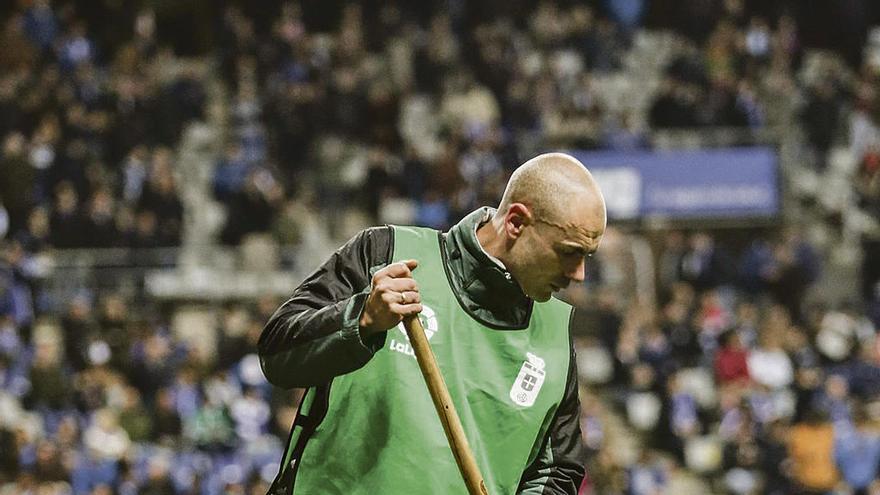 Un operario trabaja sobre el césped del Carlos Tartiere, el sábado en el descanso del partido frente al Córdoba.