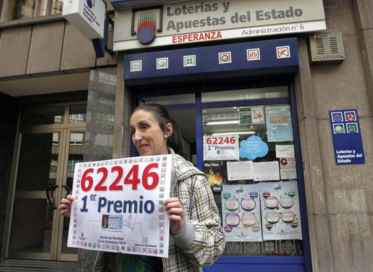 María Eugenia Casares, propietària de l’administració número 6 d’Avilés, aguanta un cartell amb el número del 62.246 premiat amb la Grossa de Nadal.