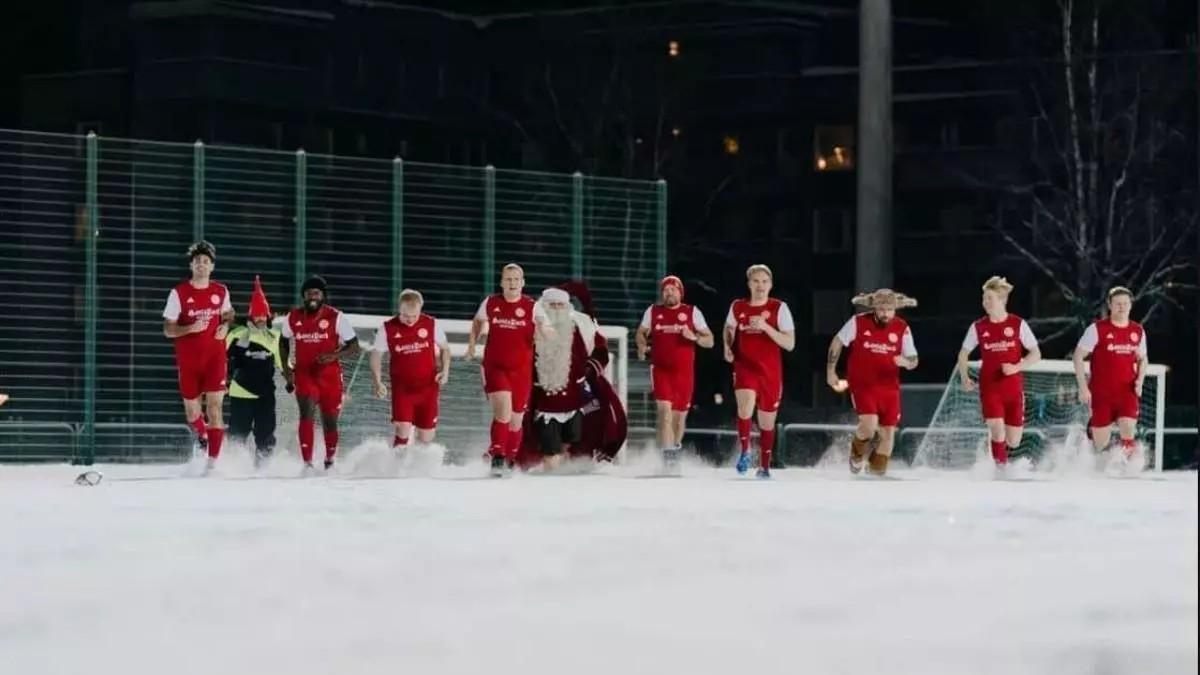 Los jugadores del FC Santa Claus con Papá Noel, su presidente honorífico, en un campo nevado
