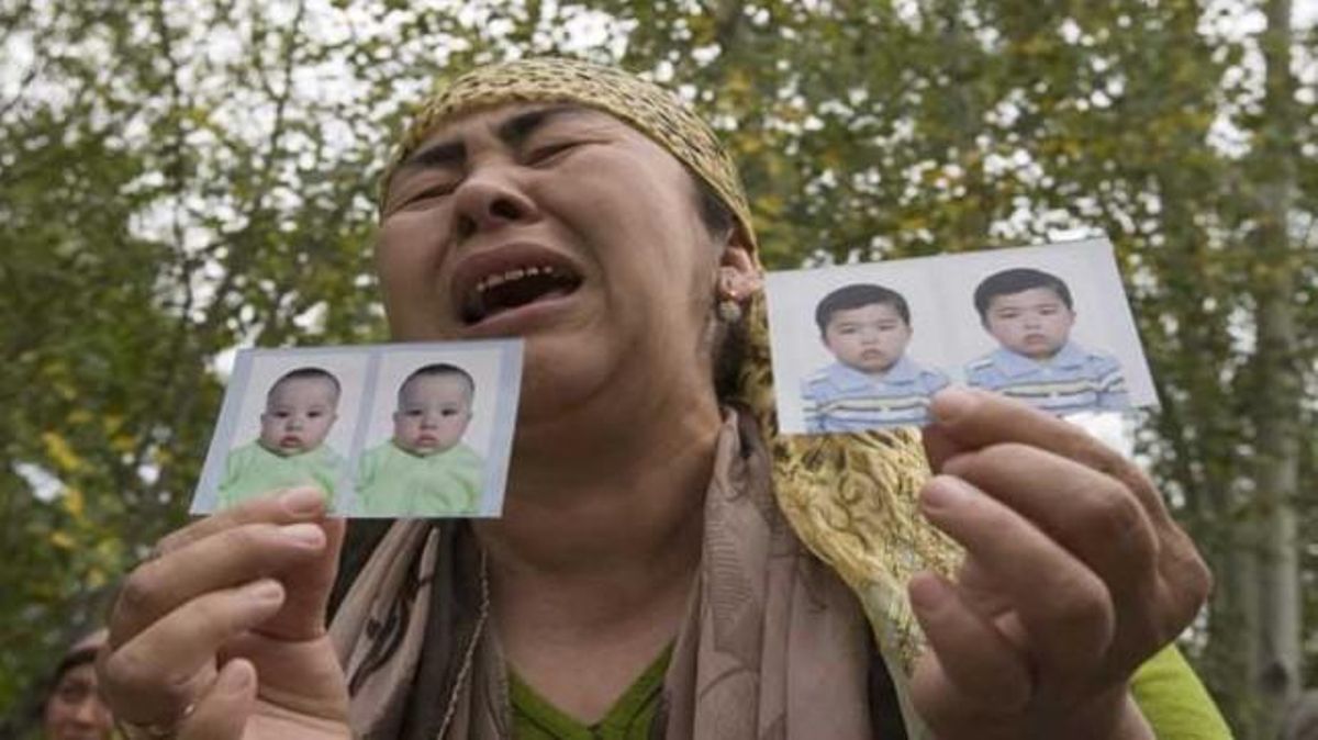 Una refugiada uzbeka mostra fotos dels seus néts desapareguts.