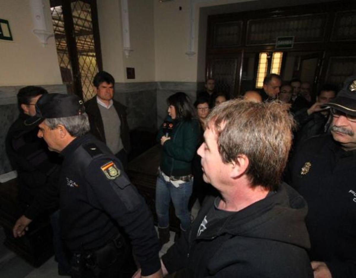 A la izquierda, el empleado de Caja Rural al que hirió «el Solitario» mira al atracador a su entrada al juicio.