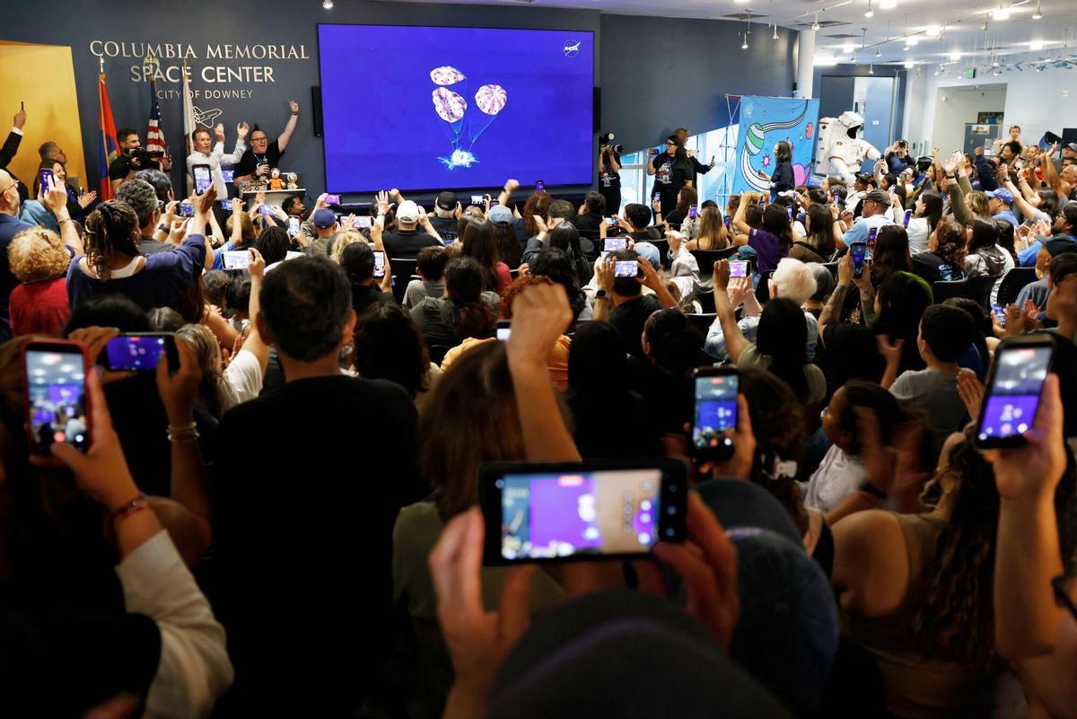 Un grupo de personas celebra el éxito del aterrizaje en el Memorial Space Center de Columbia, en Estados Unidos. Un grupo de personas celebra el éxito del aterrizaje en el Memorial Space Center de Columbia, en Estados Unidos.