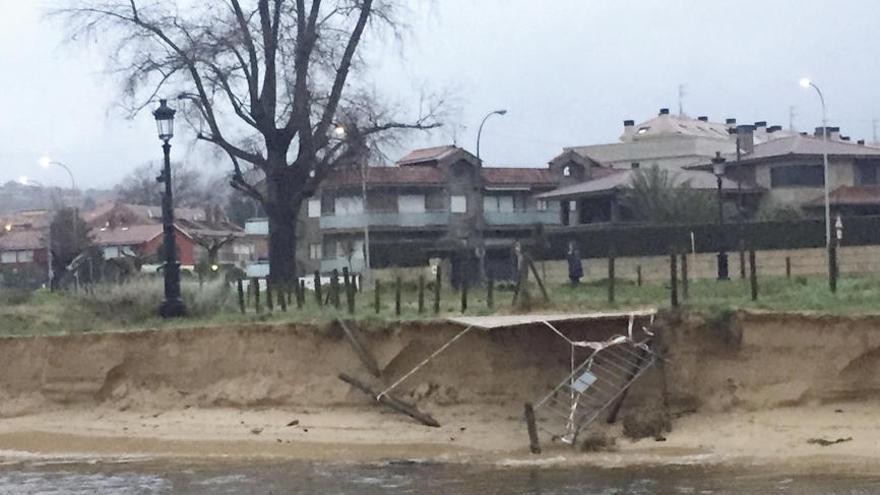 La crecida del río Muíños acelera la erosión de las dunas de Praia América y derriba un muro