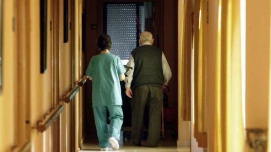 Un trabajadora de una residencia acompañando a un usuario.