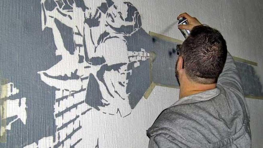 Gómez, trabajando sobre uno de sus grafitis.