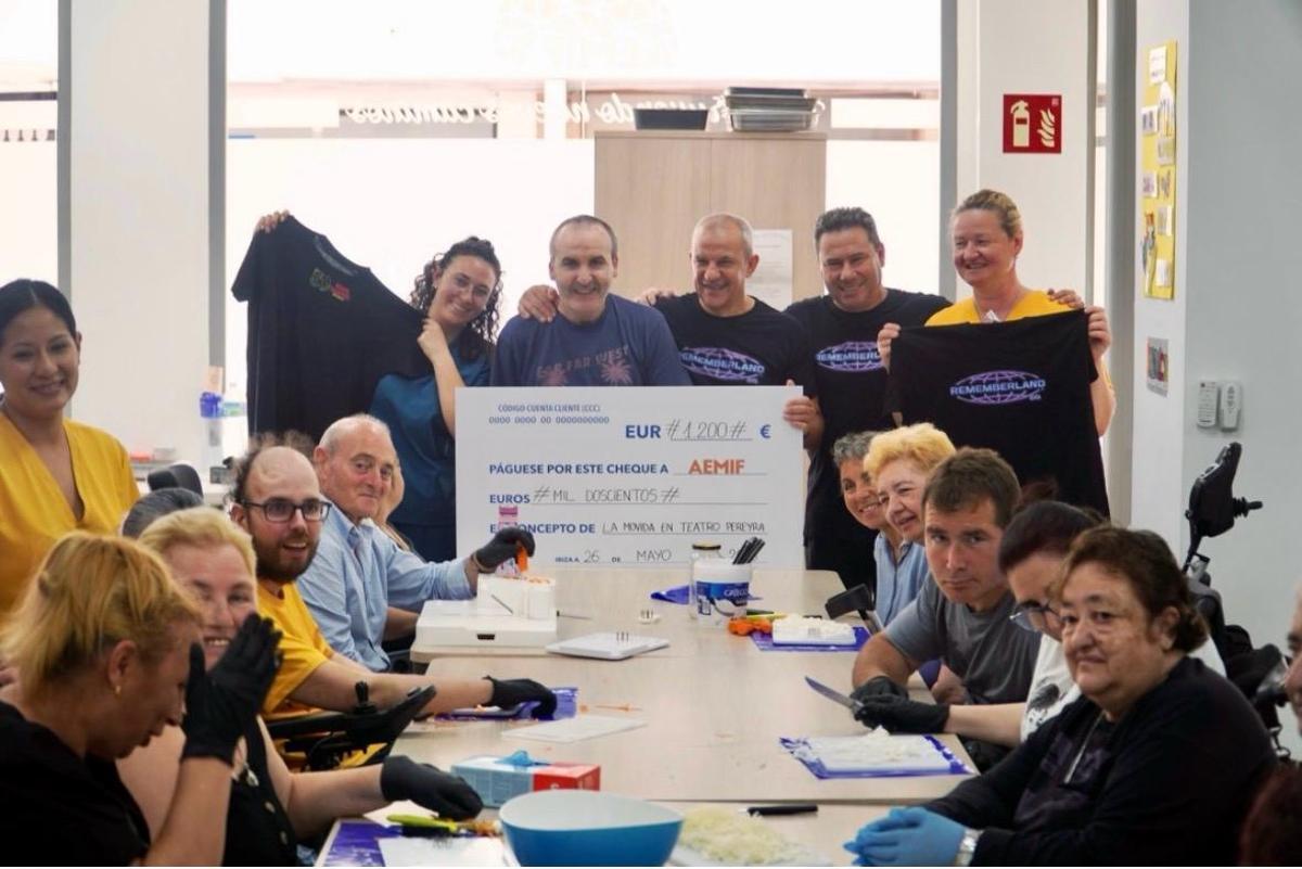 Usuarios de Aemif junto al grupo Rememberland en la entrega del cheque solidario.