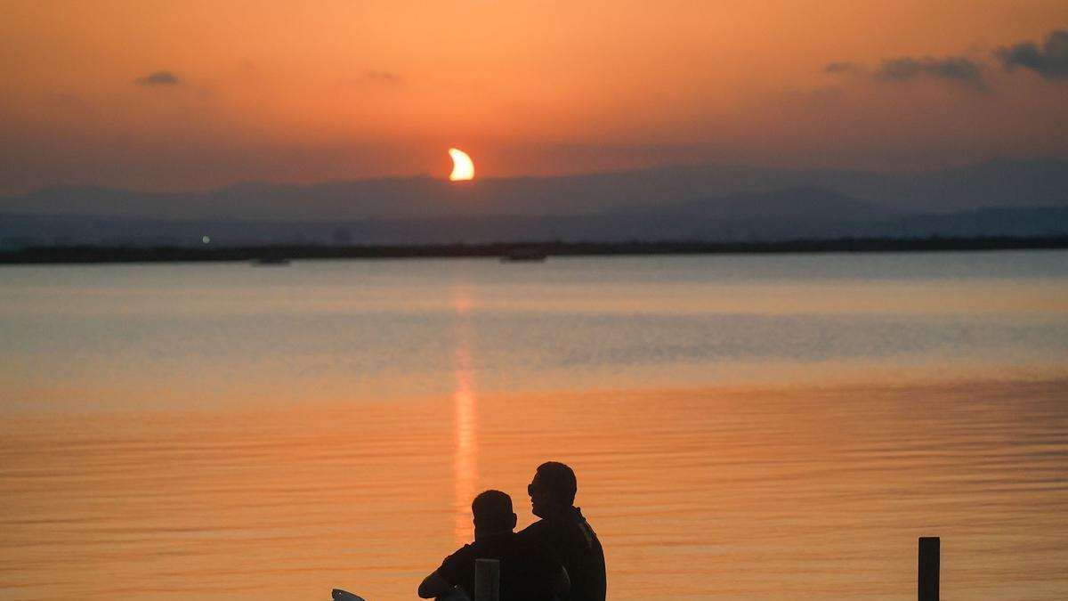 Dos ciudadanos observan el eclipse desde l'Albufera de València