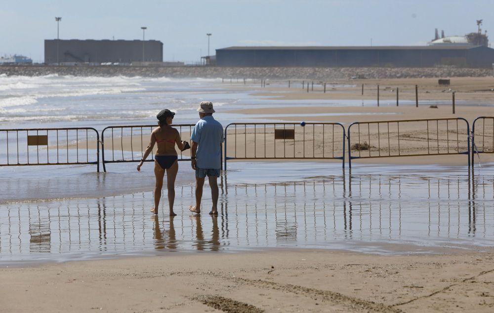 Contraste en la playa del Puerto de Sagunto, con una zona cerrada por los daños de las lluvias.