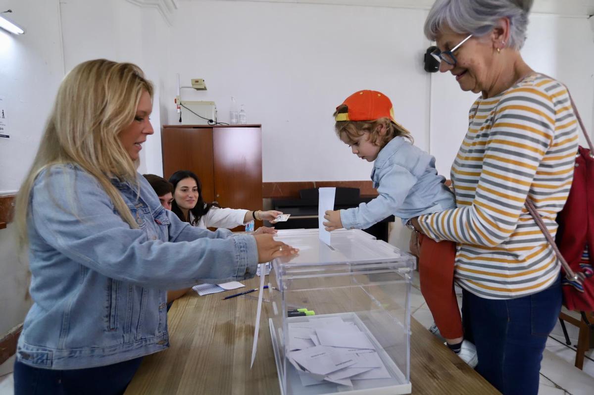 Un niño vota por su abuela en un colegio electoral en Córdoba.