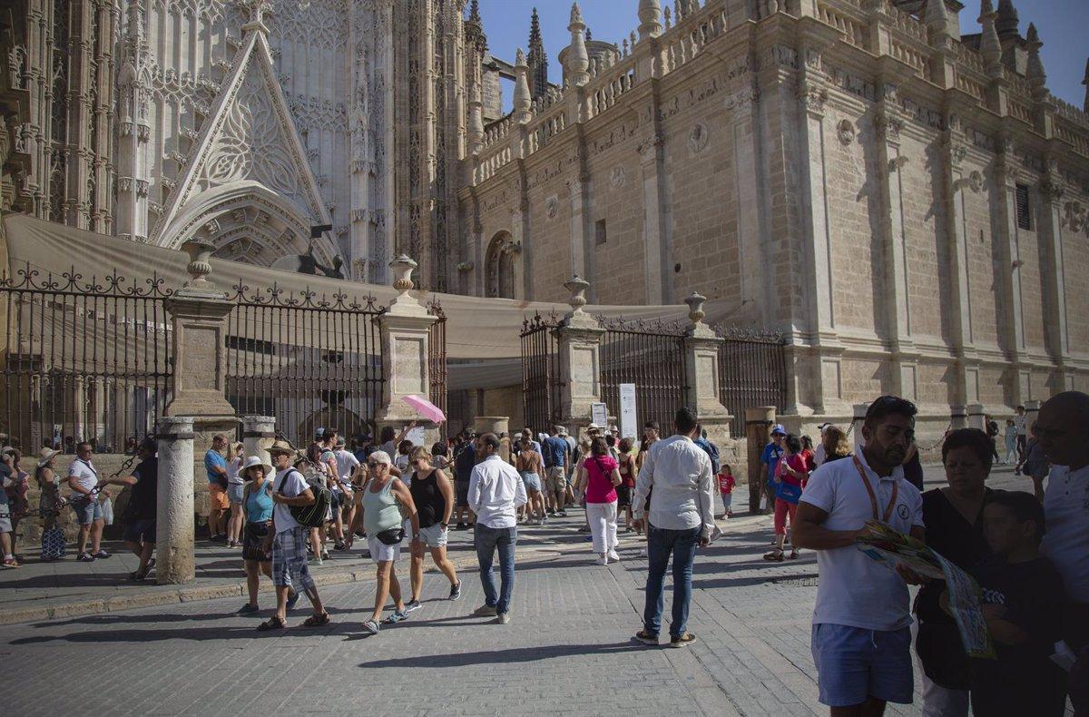 Turistas pasean y hacen cola en el entorno de la Catedral de Sevilla