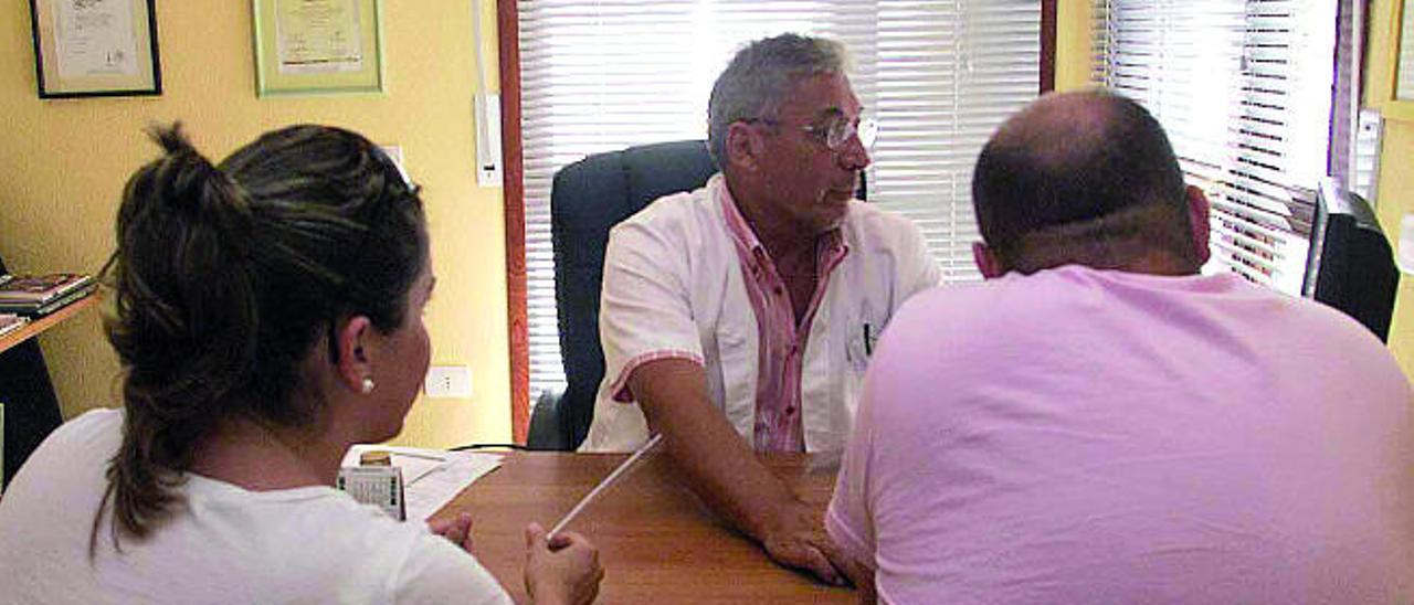 Una pareja frente al médico, en una consulta.