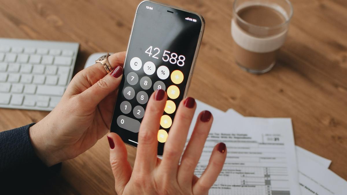 Una mujer hace cálculos para elaborar su declaración de la renta.