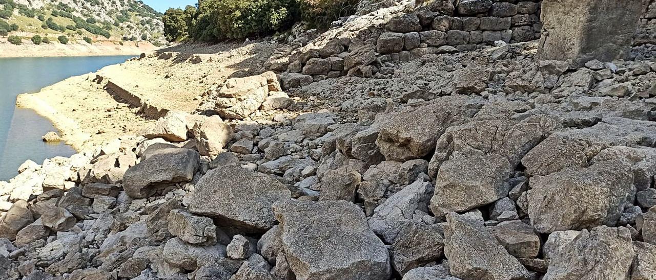 En la imagen, arriba, parte del muro del santuario de Almallutx, y en primer término, las piedras del muro izquierdo derruidas.  | J.D.